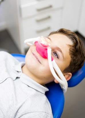 Young boy getting prepped for sedation at dentist office.